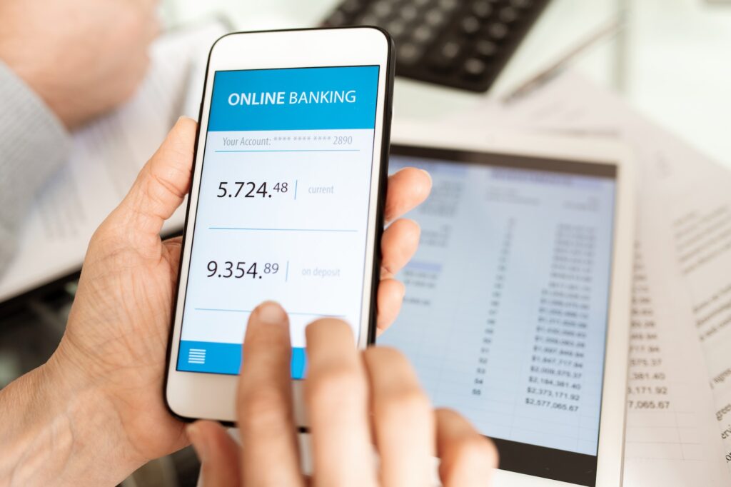 Hands of businessperson with smartphone scrolling through online banking account